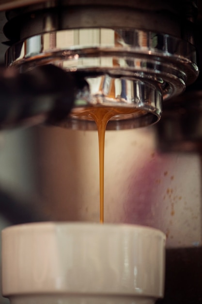 Foto gratuita primo piano della macchina del caffè che produce bevanda del caffè espresso