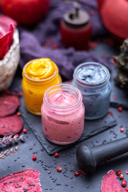 Closeup of colorful spices for vegan food in small jars on the table with dehydrated beetroots