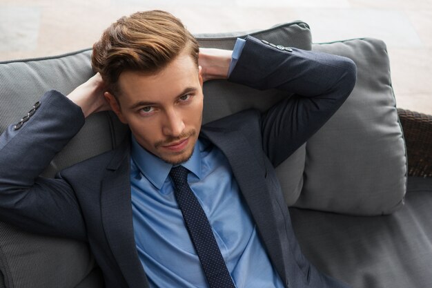 Closeup of Content Businessman Resting on Cushions