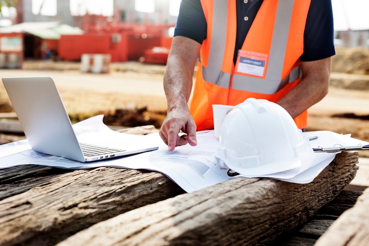 Free Photo closeup of contractor in construction site pointing at plan on wooden sleeper