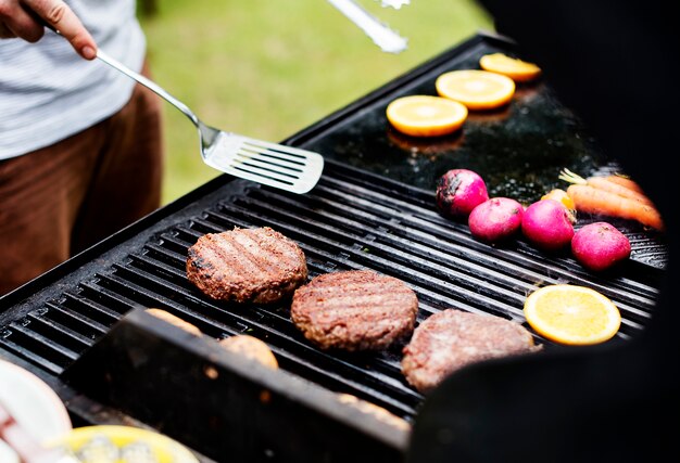 Closeup of cooking hamburger patties on the charcoals grill