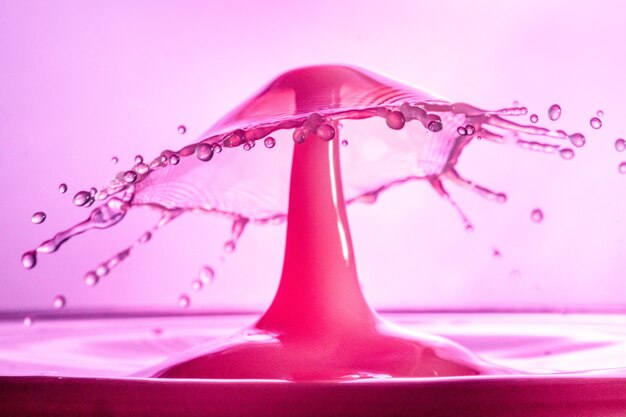 Крупным планом прохладный розовый фон всплеск воды