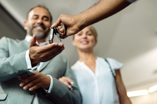 Closeup of a couple receiving car keys in a workshop