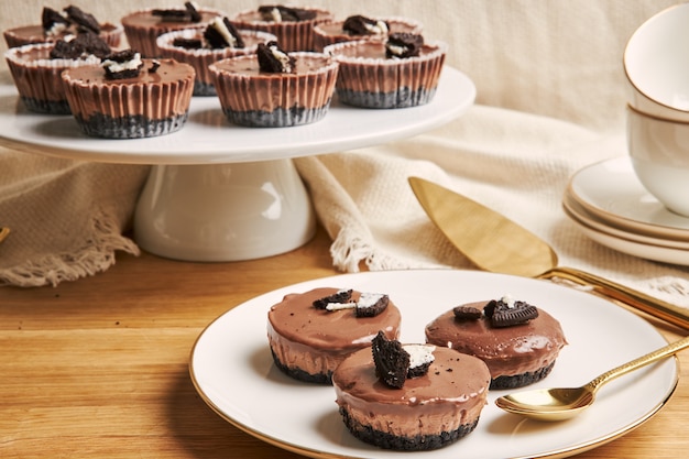 Closeup of creamy chocolate muffins with cookie toppings on plates under the lights