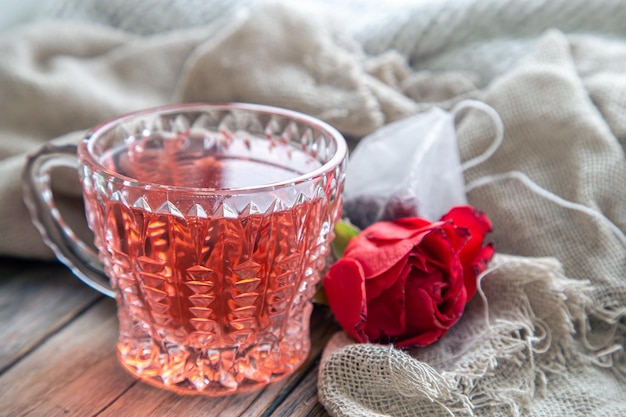 Closeup a cup of red tea and a rose