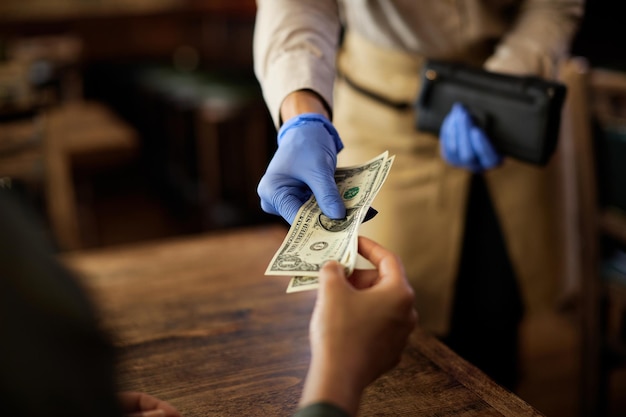 Foto gratuita primo piano del cliente che paga a una cameriera in un caffè