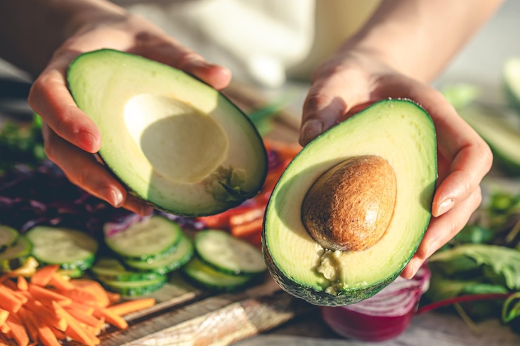 Free Photo closeup of a cut avocado in a womans hands