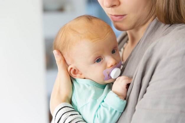 Closeup of cute adorable red haired baby with soother