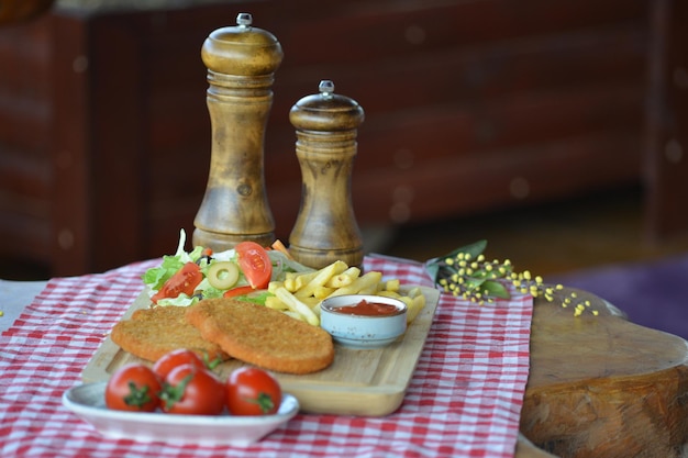 Primo piano di una deliziosa colazione di patatine fritte polpette di pesce fritto insalata e salsa sul tavolo