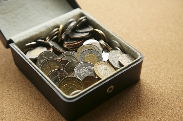 Closeup of different coins in a box on the table