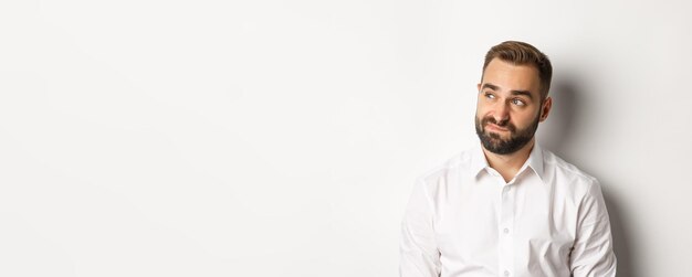 Free photo closeup of doubtful and gloomy man looking left sighing uncertain standing over white background