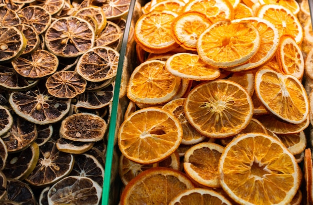 Closeup of the dried oranges and grapefruits in the glass containers in the market