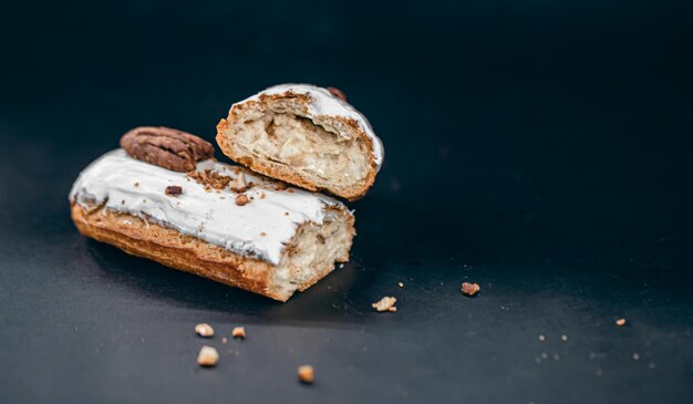 Closeup of eclair in white glaze with pecans