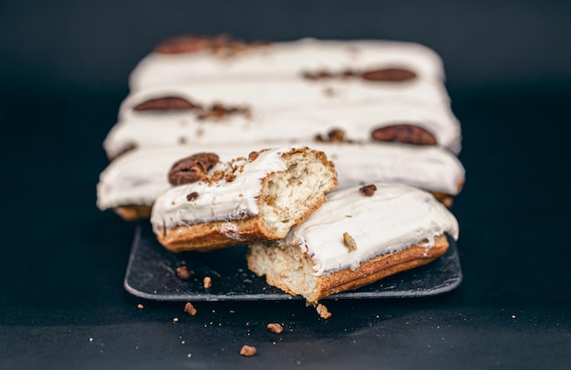 Closeup of eclairs in white glaze with pecans