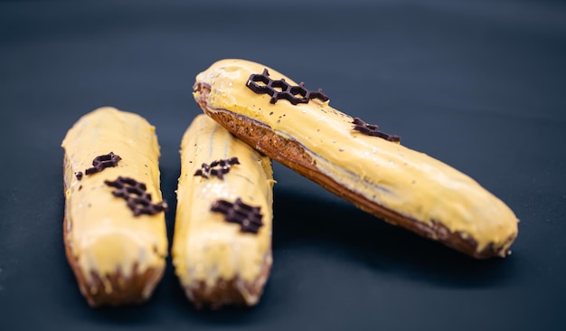 Closeup of eclairs in yellow glaze on a black background