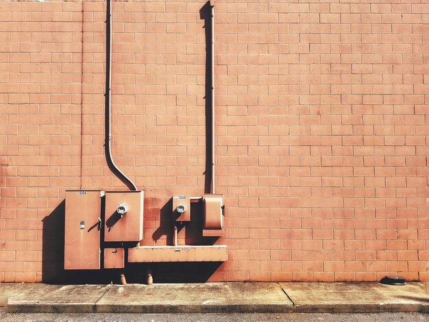 Closeup of electrical fuse boxes on a brown brick wall