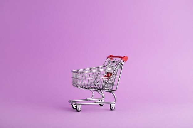 Free photo closeup of an empty trolley ready for christmas shopping, purple background