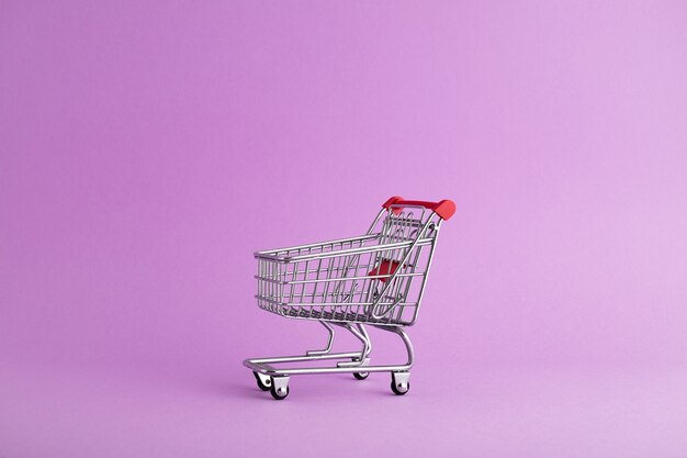 Closeup of an empty trolley ready for Christmas shopping, purple background