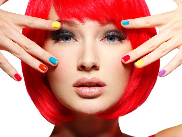 Closeup face of a beautiful  girl with bright multicolor nails.