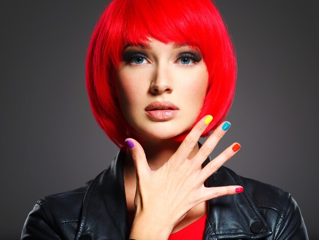 Closeup face of a beautiful  girl with bright multicolor nails.