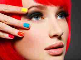Free photo closeup face of a beautiful  girl with bright multicolor nails.
