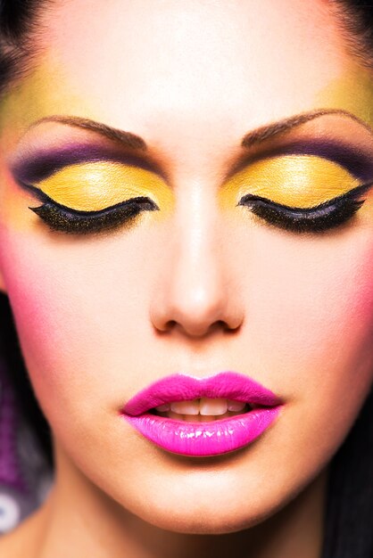 Closeup face of beautiful woman with fashion bright colour makeup