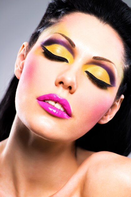 Closeup face of beautiful woman with fashion bright colour makeup