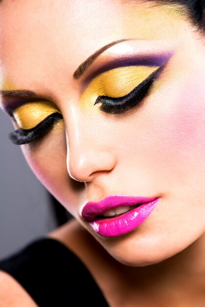 Closeup face of beautiful woman with fashion bright colour makeup