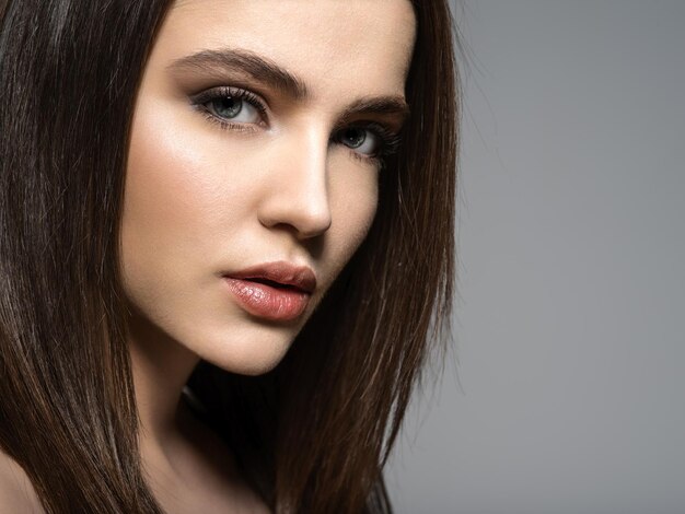 Closeup face of a Fashion model with straight   hair.  Fashion model posing .
Pretty woman with long straight brown hair 