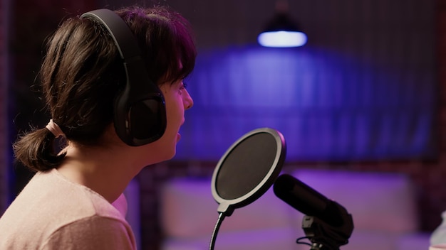 Closeup of famous influencer in online radio show talking with male host about social media success using professional microphone. Woman having casual converstion while recording podcast.