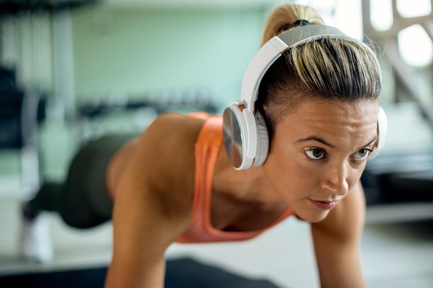 Primo piano dell'atleta femminile che si esercita nella posa della plancia al club di salute