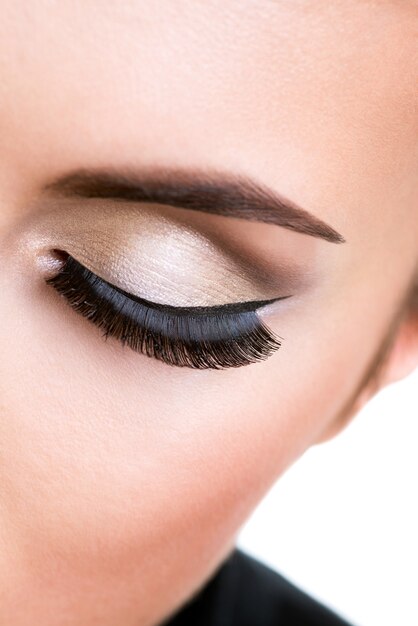 Closeup female eye with beautiful fashion makeup with long false eyelashes.