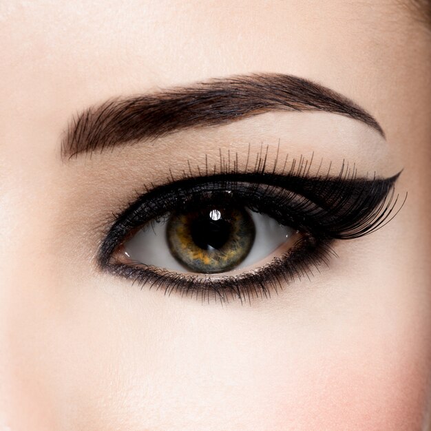 Closeup female eye with creative fashion make-up. brown eyeshadow