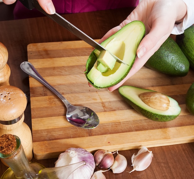 Макрофотография женских рук приготовления пищи с авокадо