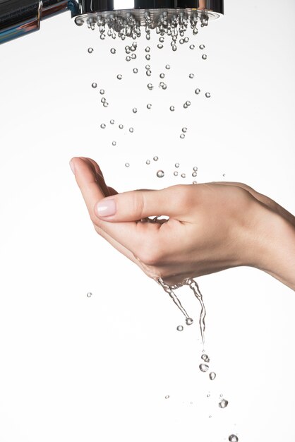 Free photo closeup female hands under the falling drops of water