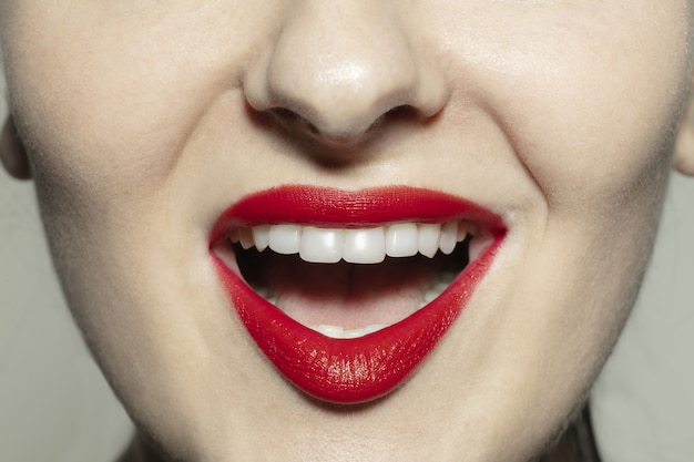 真っ赤な光沢のある唇とクローズアップの女性の口