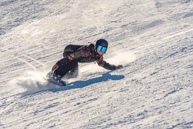 Foto gratuita primo piano di una donna snowboarder in movimento su uno snowboard in montagna