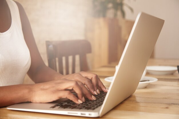 Closeup of female typing on laptop keyboard