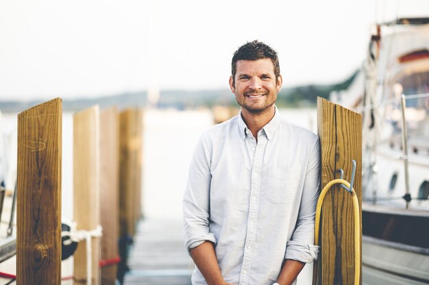 Closeup focus portrait of a handsome adult man standing at a pier