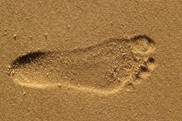 Closeup of a footprint of a human on sand
