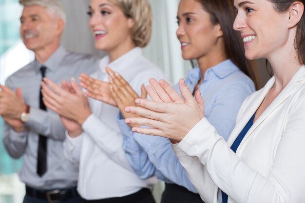 Closeup of Four Smiling Business People Applauding