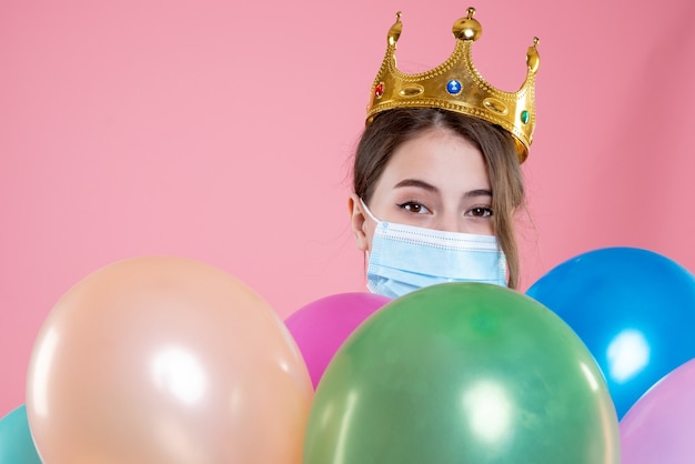 Free photo closeup front view party girl with crown holding balloons