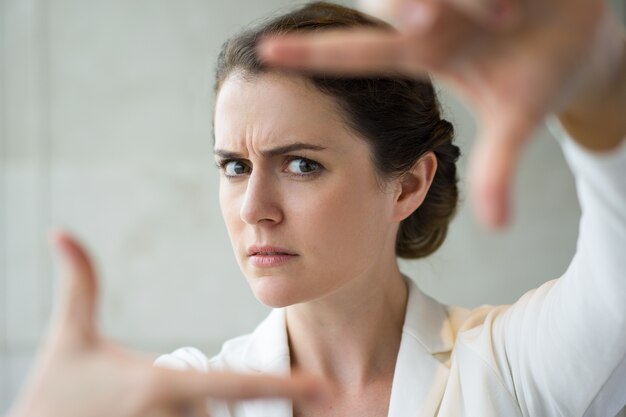 Closeup of Frowning Woman Making Frame Gesture