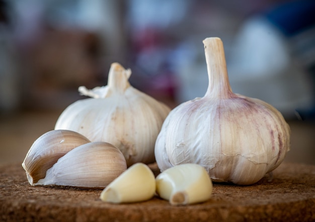 Closeup of garlic bulb and cloves on a round cork board