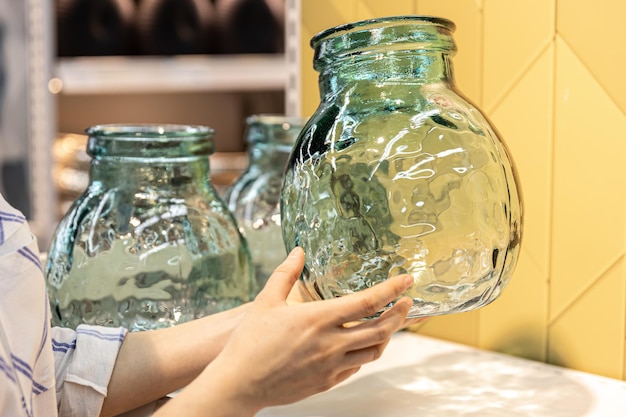 Closeup a glass jar in female hands on a shop window