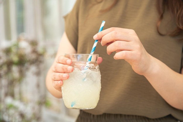 Closeup a glass of lemonade in female hands