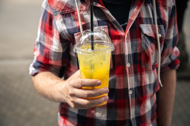 Closeup a glass of lemonade in male hands