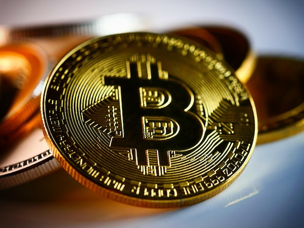 Closeup of the golden bitcoin with other cryptocurrencies on background