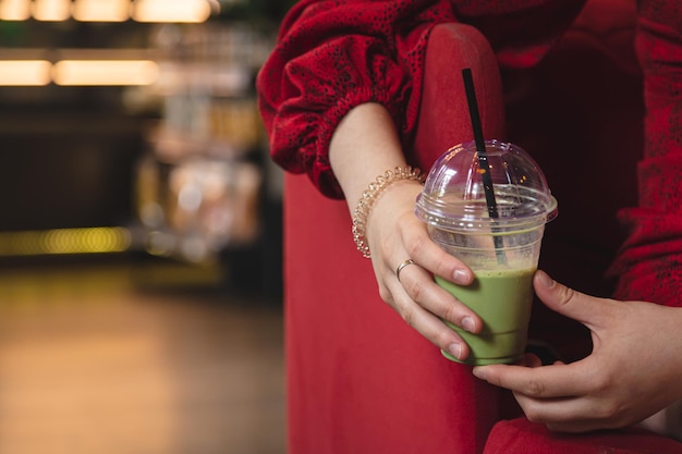 カフェのぼやけた背景にクローズアップグリーンドリンクアイス抹茶ラテ