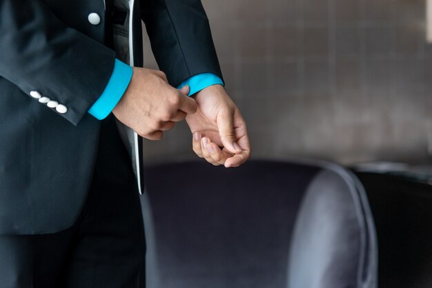 Closeup of the groom in his tuxedo fixing his cufflinks